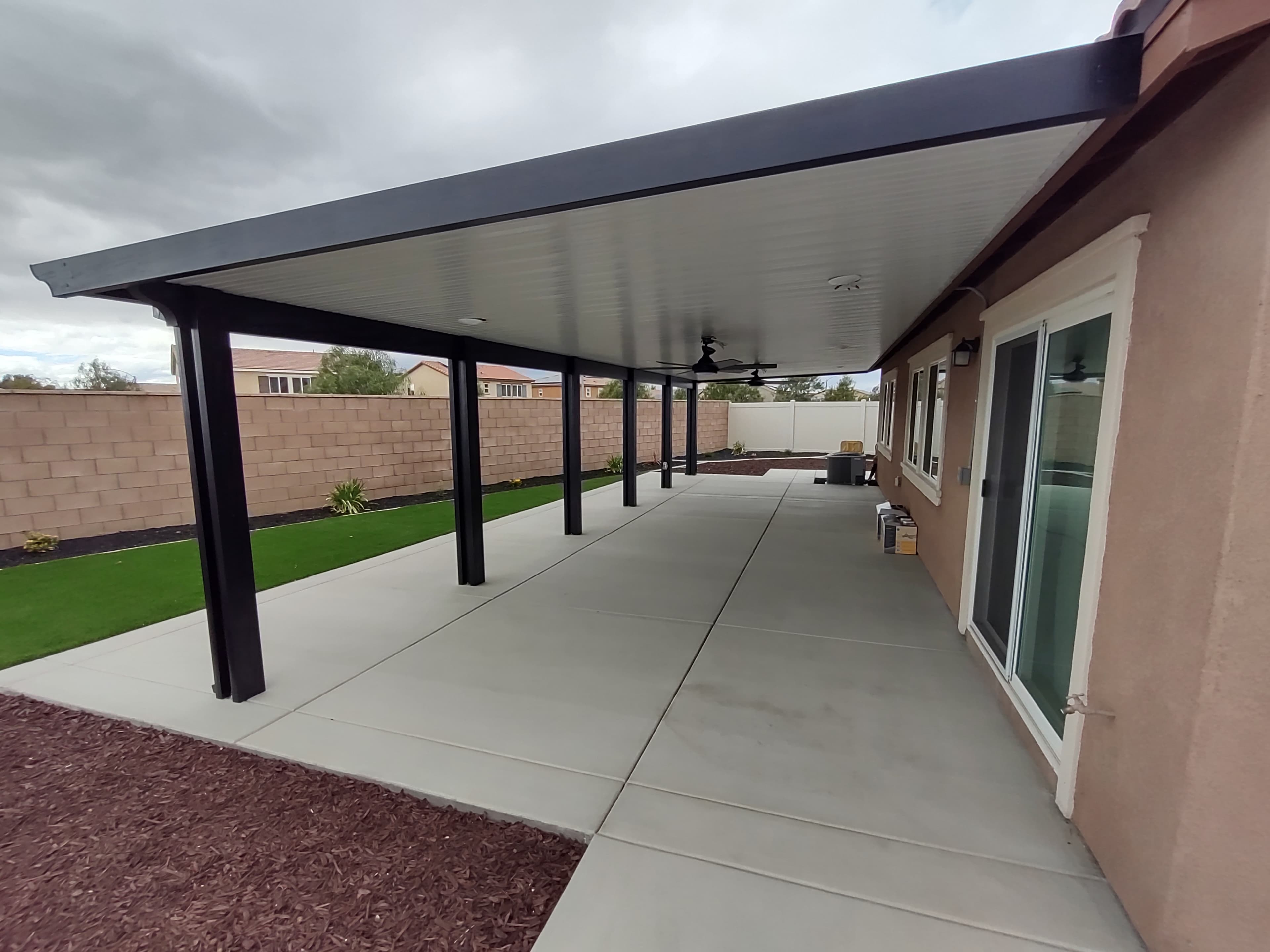 Backyard with aluminum patio cover adding usable outdoor living space